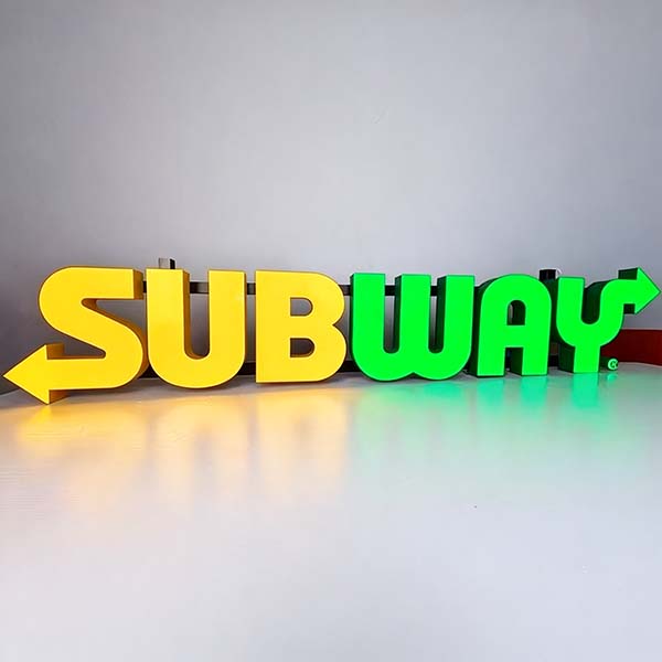 Yellow illuminated storefront letters sized to a shop fascia